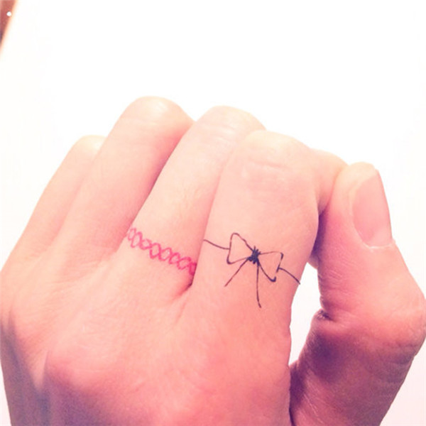 Cute Little Bow Ring Tattoo On Finger