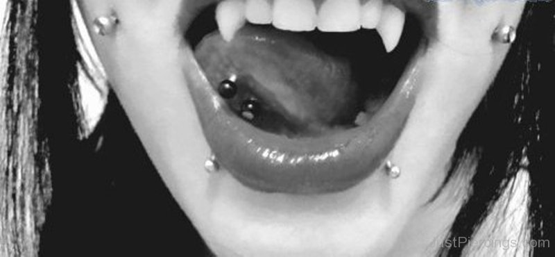 Girl Have Cheek Piercings, Tongue Piercing And Lower Lip Snake Bites Piercing