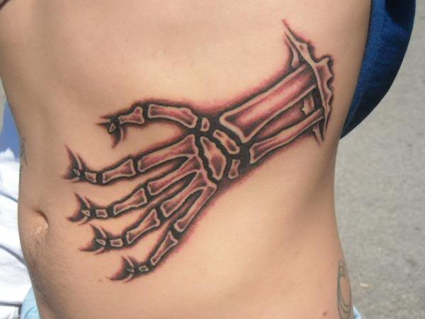 Ripped Skin Skeleton Hand Tattoo On Side Rib