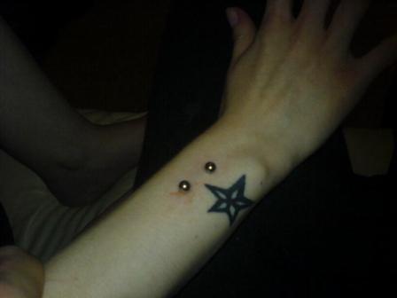 Star Tattoo And Vertical Wrist Piercing