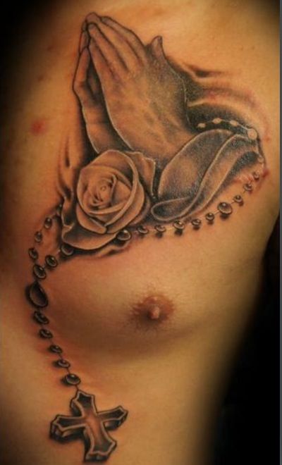 Amazing 3D Rosary Cross In Praying Hand With Rose Tattoo On Man Chest