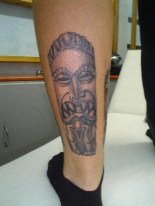 Black And Grey Tiki Tattoo On Leg