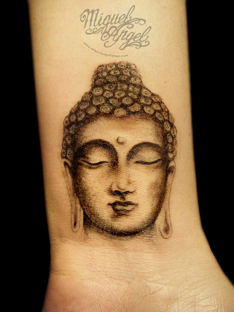 Black Buddha Face Tattoo On Wrist By Miguel Angel