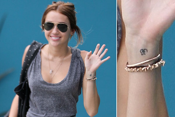 Black Little Hinduism Om Tattoo On Miley Cyrus Wrist