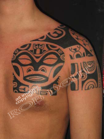 Black Tribal Tiki Tattoo On Man Chest