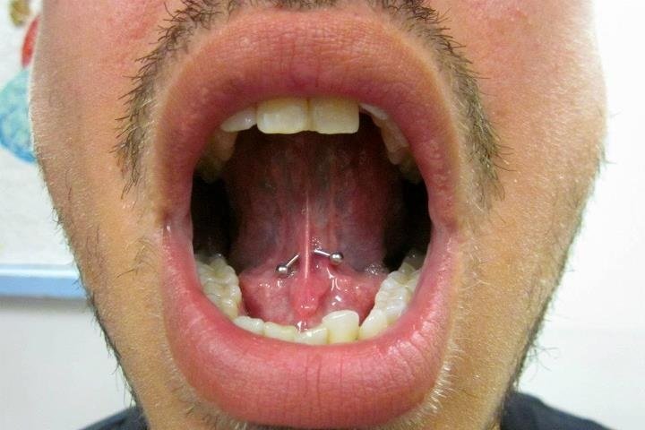 Man Showing His Curved Silver Barbell Tongue Web Piercing
