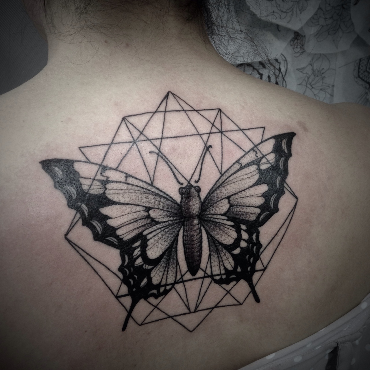 Black And Grey Geometric Butterfly Tattoo On Girl Upper Back