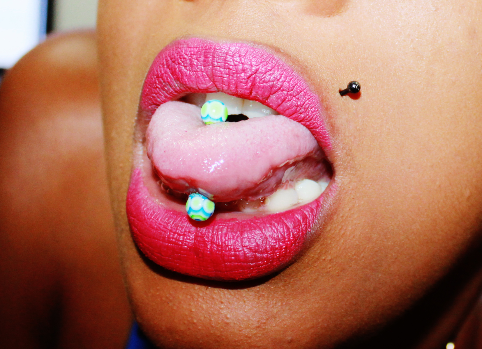 Black Stud Monroe And Tongue Piercing Image.