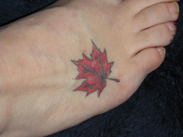 Red And Black Maple Leaf Tattoo On Foot