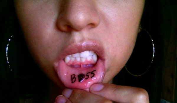 Black Boss Lettering Tattoo On Girl Inner Lip
