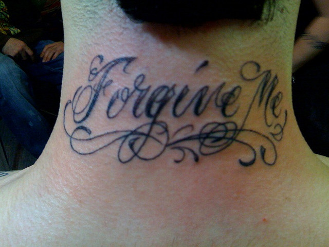 Black Forgive Me Lettering Tattoo On Man Back Neck