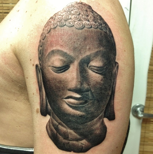 Black Ink Buddha Face Statue Tattoo On Shoulder