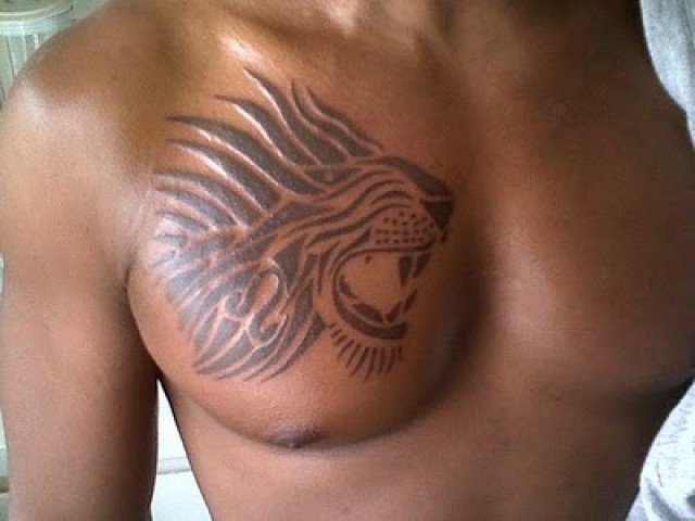Black Tribal Lion Head Tattoo On Man Chest