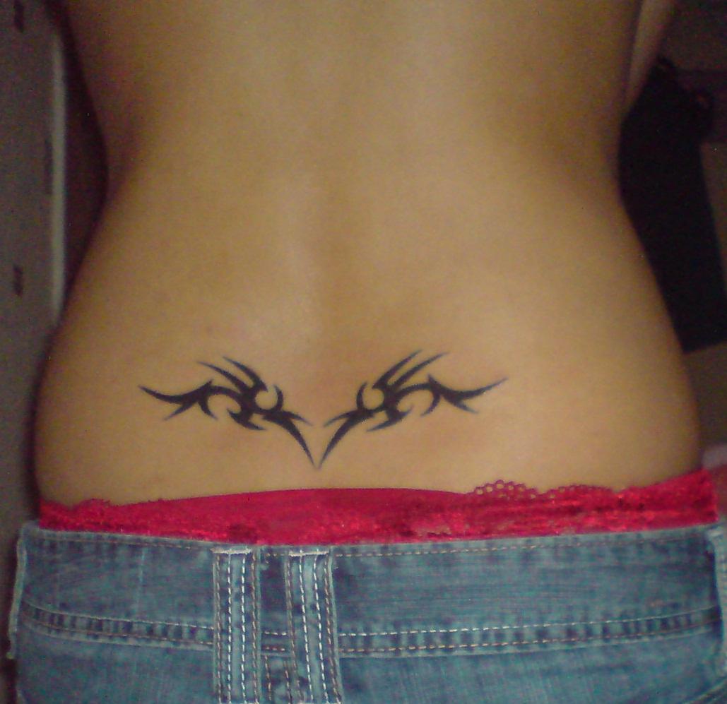 Black Tribal Swirl Tattoo On Girl Lower Back