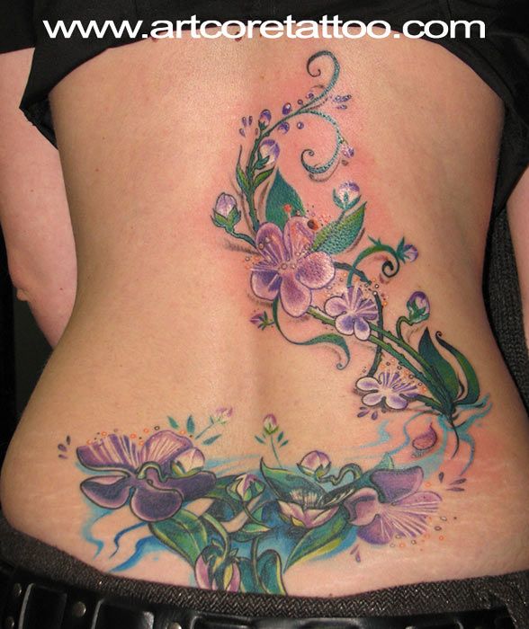 Colorful Flowers With Leaves Tattoo On Girl Lower Back