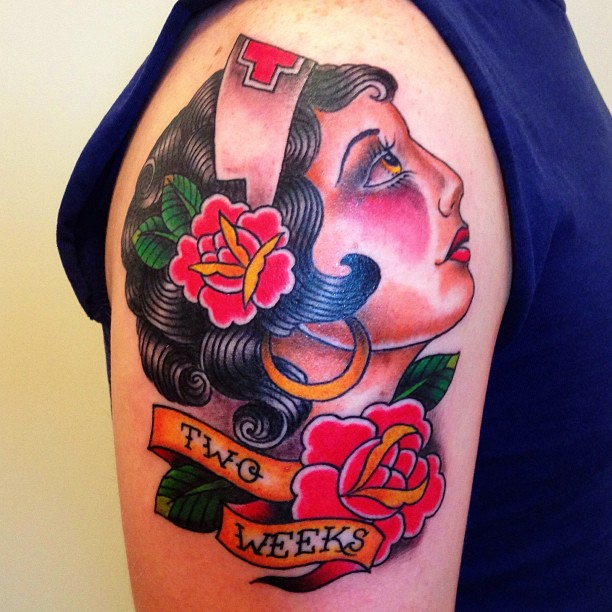 Colorful Nurse Face With Banner And Flowers Tattoo On Right Shoulder