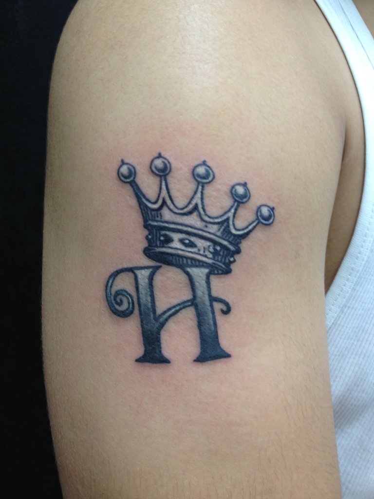 Grey Ink H With Crown Tattoo On Shoulder