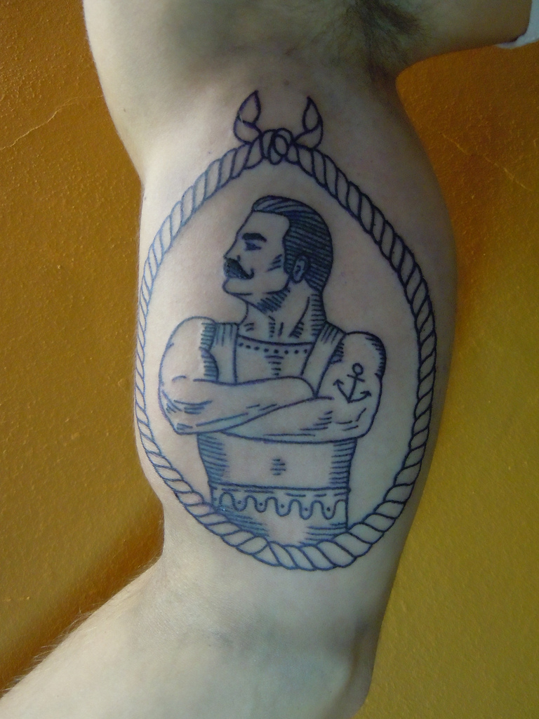 Man In Rope Frame Tattoo On Man Bicep
