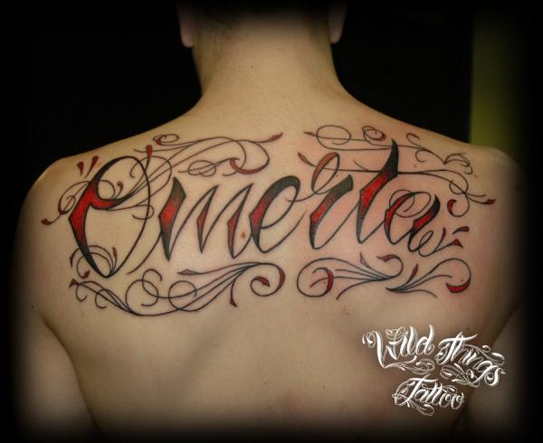 Red And Black Omerta Lettering Tattoo On Man Upper Back By Wild Things Tattoo