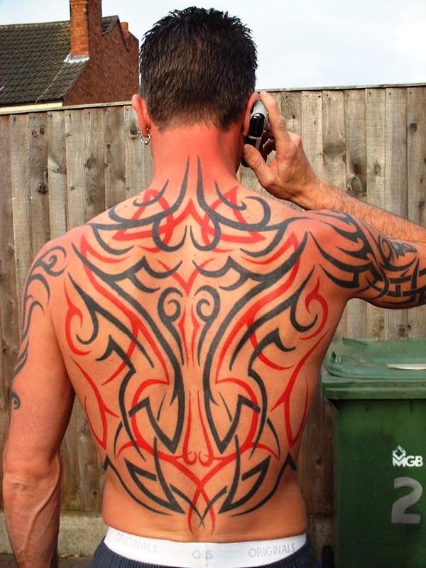 Red And Black Tribal Design Tattoo On Man Full Back
