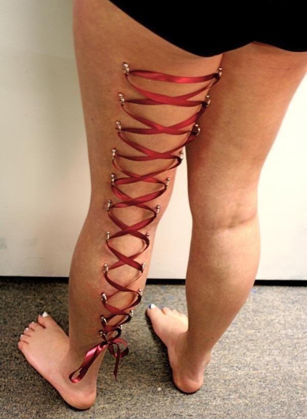 Red Ribbon Corset Piercing On Girl Left Back Leg
