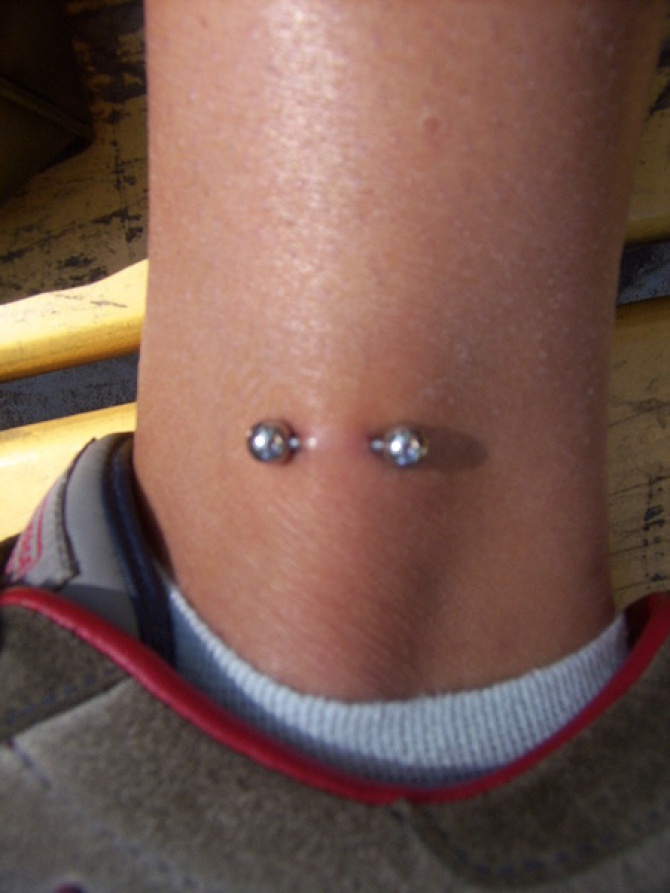 Silver Barbell Leg Piercing Image