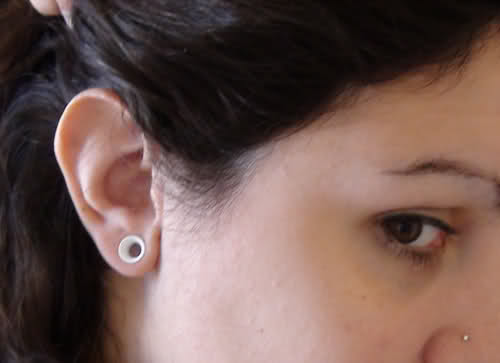 Small White Gauge Ear Stretching On Girl Right Ear
