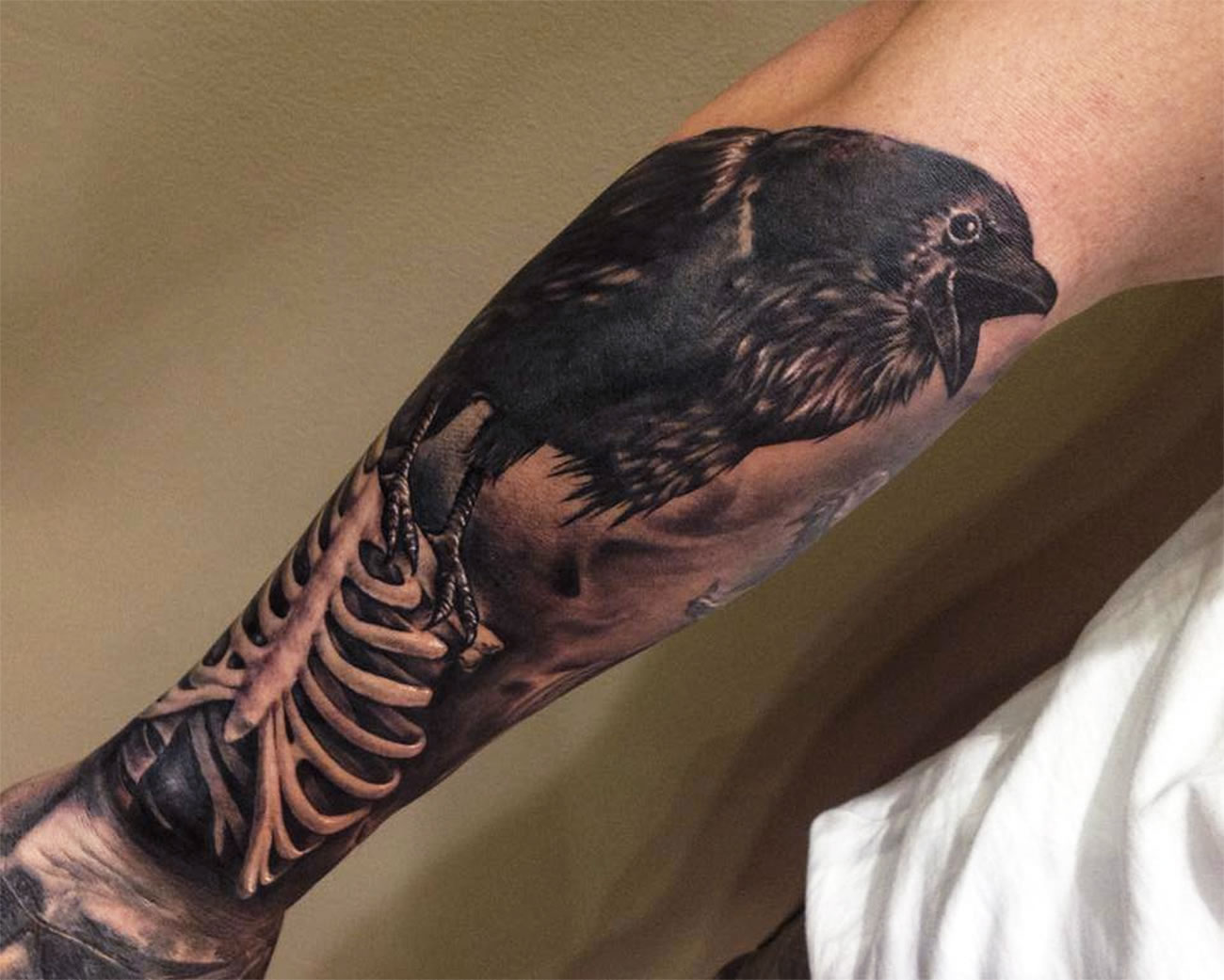 Awesome Crow Sit On Rib Cage Tattoo On Forearm