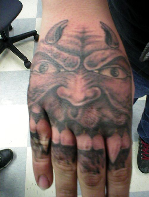 Black And Grey Devil Face In Hand