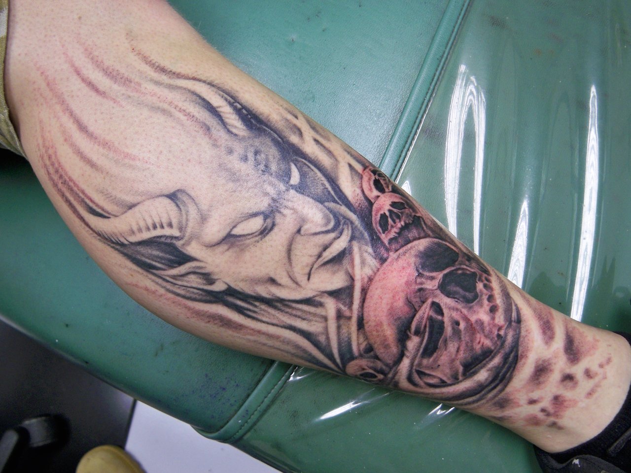 Black And Grey Devil Face With Tattoo On Leg