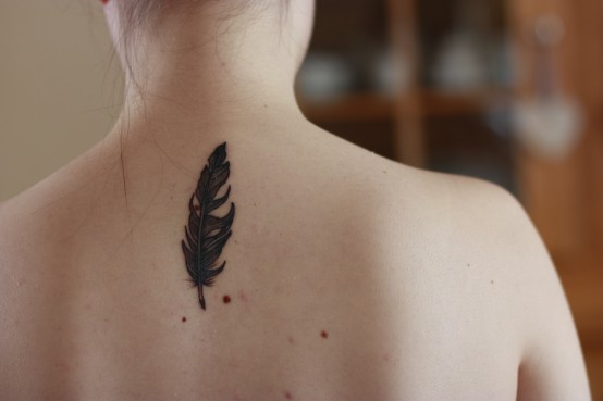 Black Feather Tattoo On Girl Upper Back