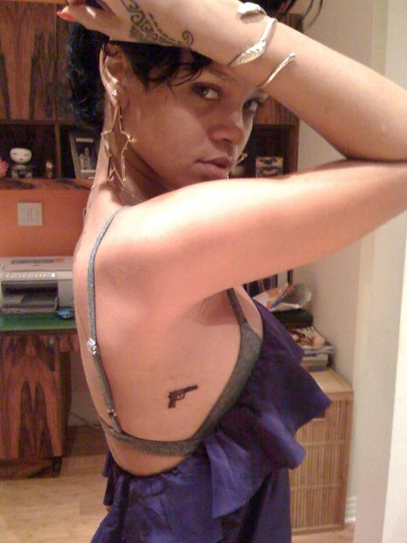 Black Ink Gun Tattoo On Rihanna Upper Rib