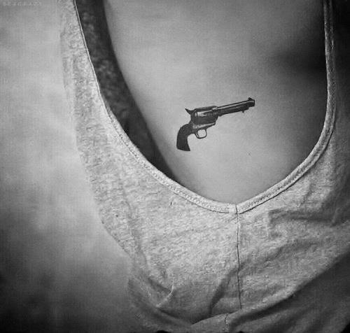 Black Ink Gun Tattoo On Upper Rib