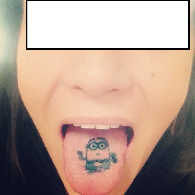 Black Ink Minion Tattoo On Girl Tongue