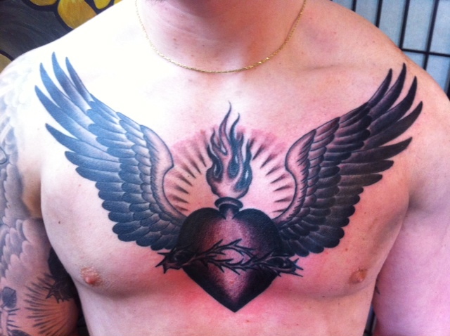 Black Ink Sacred Heart With Wings Tattoo On Man Chest