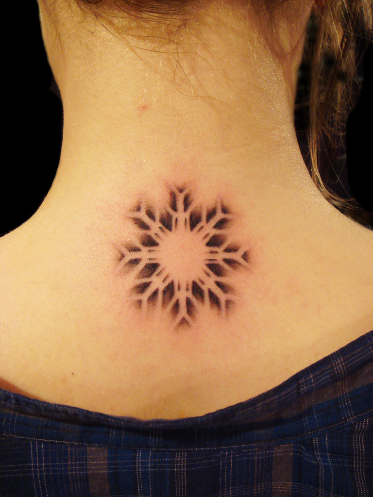 Black Ink Snowflake Tattoo On Upper Back By Squeal
