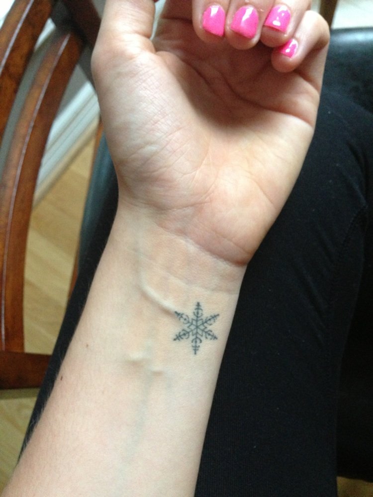 Black Little Snowflake Tattoo On Girl Wrist