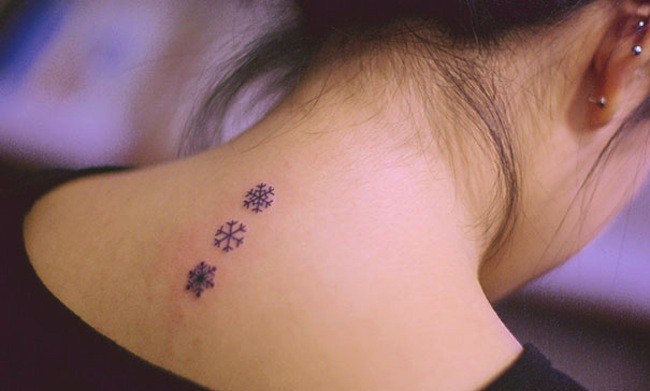 Black Three Snowflakes Tattoo On Girl Upper Back