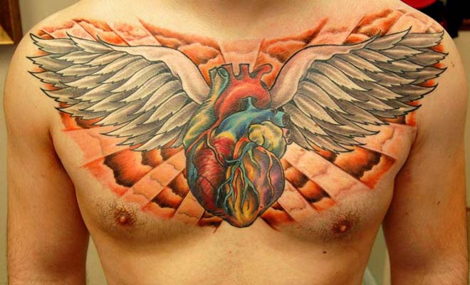 Colorful Sacred Real Heart With Wings Tattoo On Man Chest