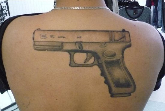 Grey Ink Gun Tattoo On Upper Back