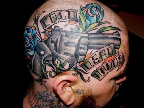 Gun With Roses And Banner Tattoo On Man Head