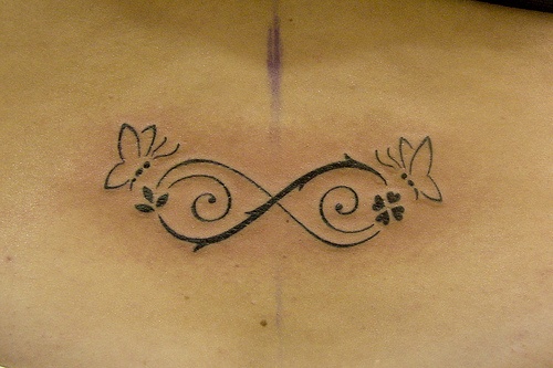 Outline Infinity And Butterfly Tattoo On Lower Back