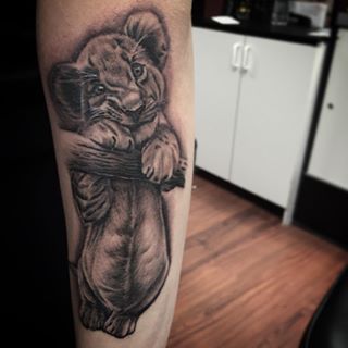 Black Ink Cute Lion Cub Tattoo On Forearm
