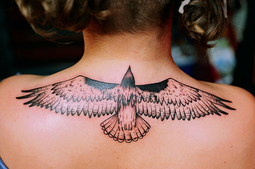 Black Ink Flying Hawk Tattoo On Girl Upper Back