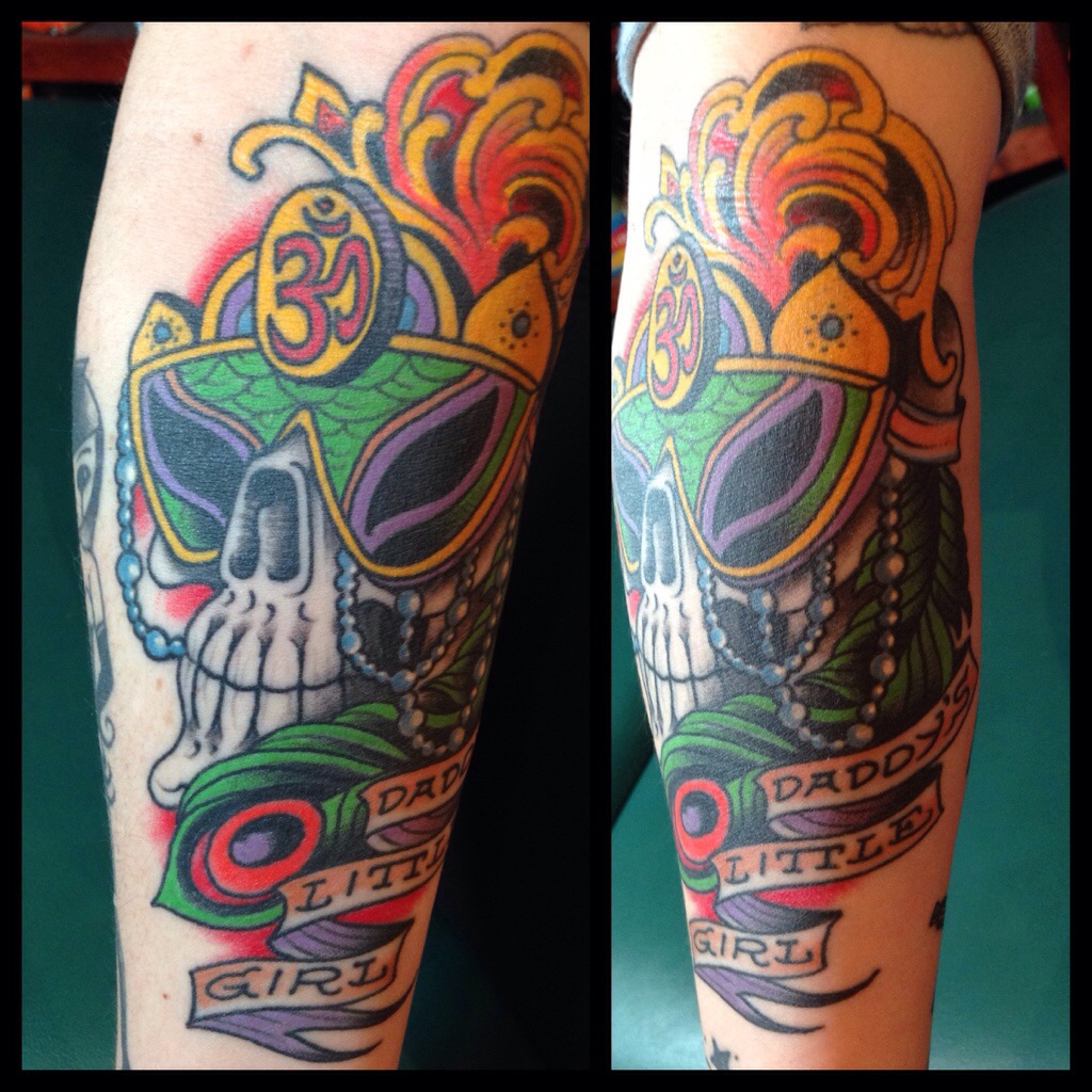 Colorful Mardi Gras Skull Mask With Banner Tattoo Design