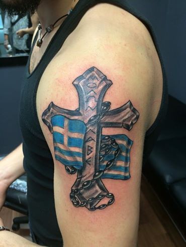 Cross With Greek Flag Tattoo On Man Left Shoulder