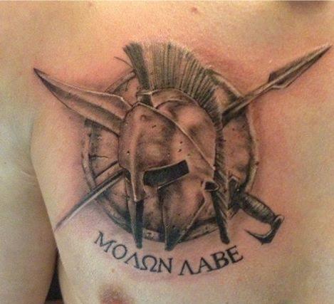 Greek Warrior Helmet With Shield And Weapon Tattoo On Man Chest