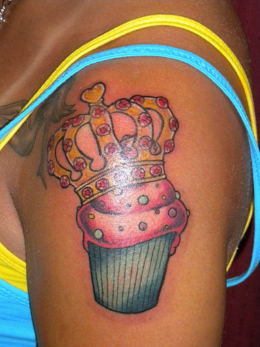 Queen Crown On Cupcake Tattoo On Girl Left Shoulder