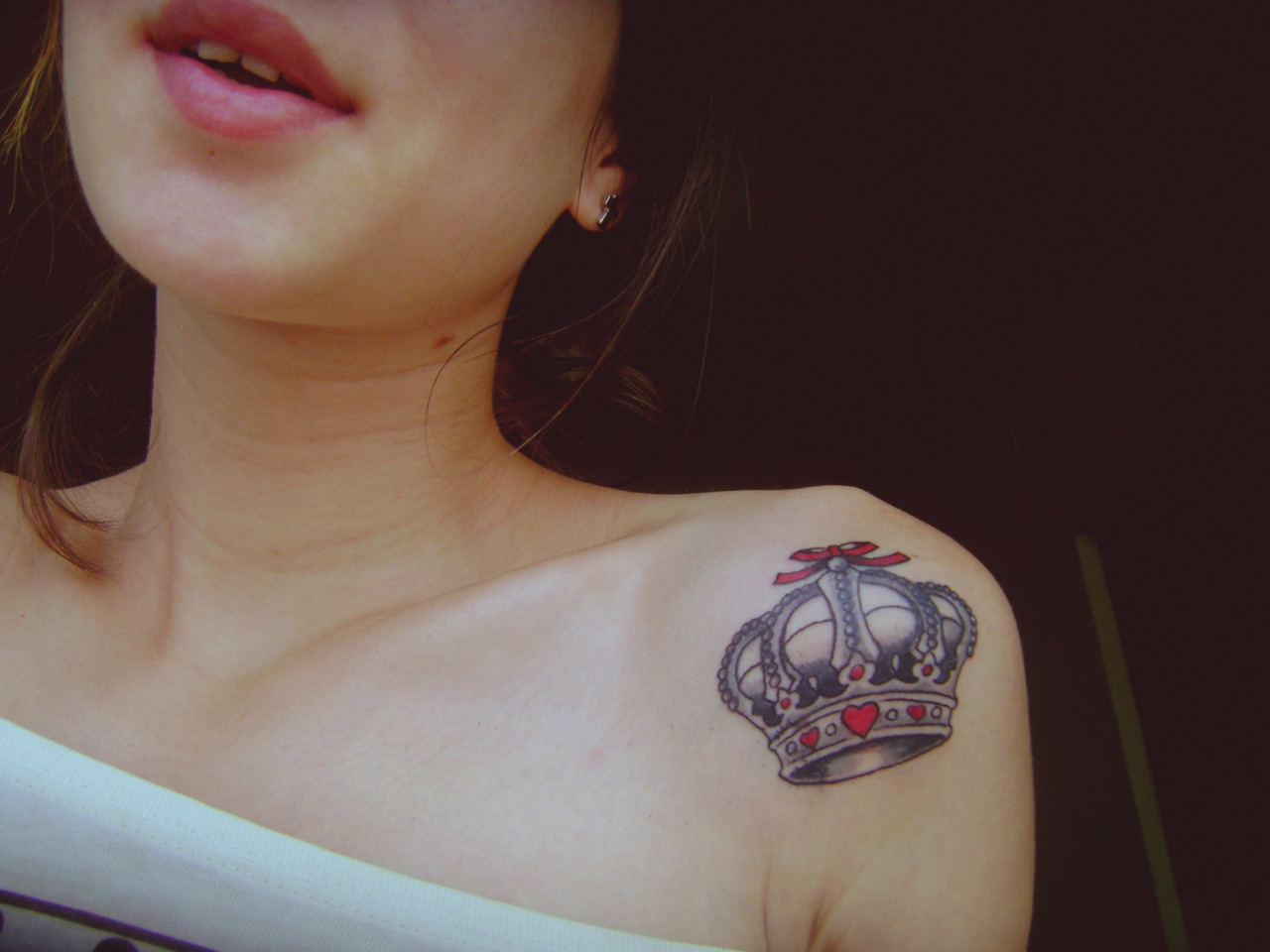Red And Black Queen Crown Tattoo On Girl Left Shoulder
