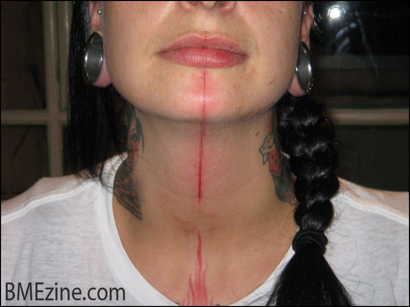 Red Ink Line Tattoo On Girl Chin And Neck